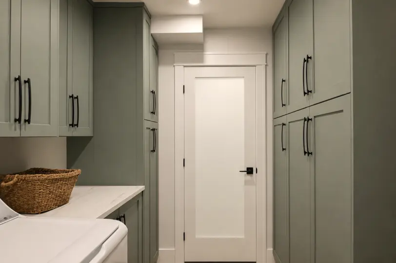 Sage green laundry room cabinetry by King Cabinetry